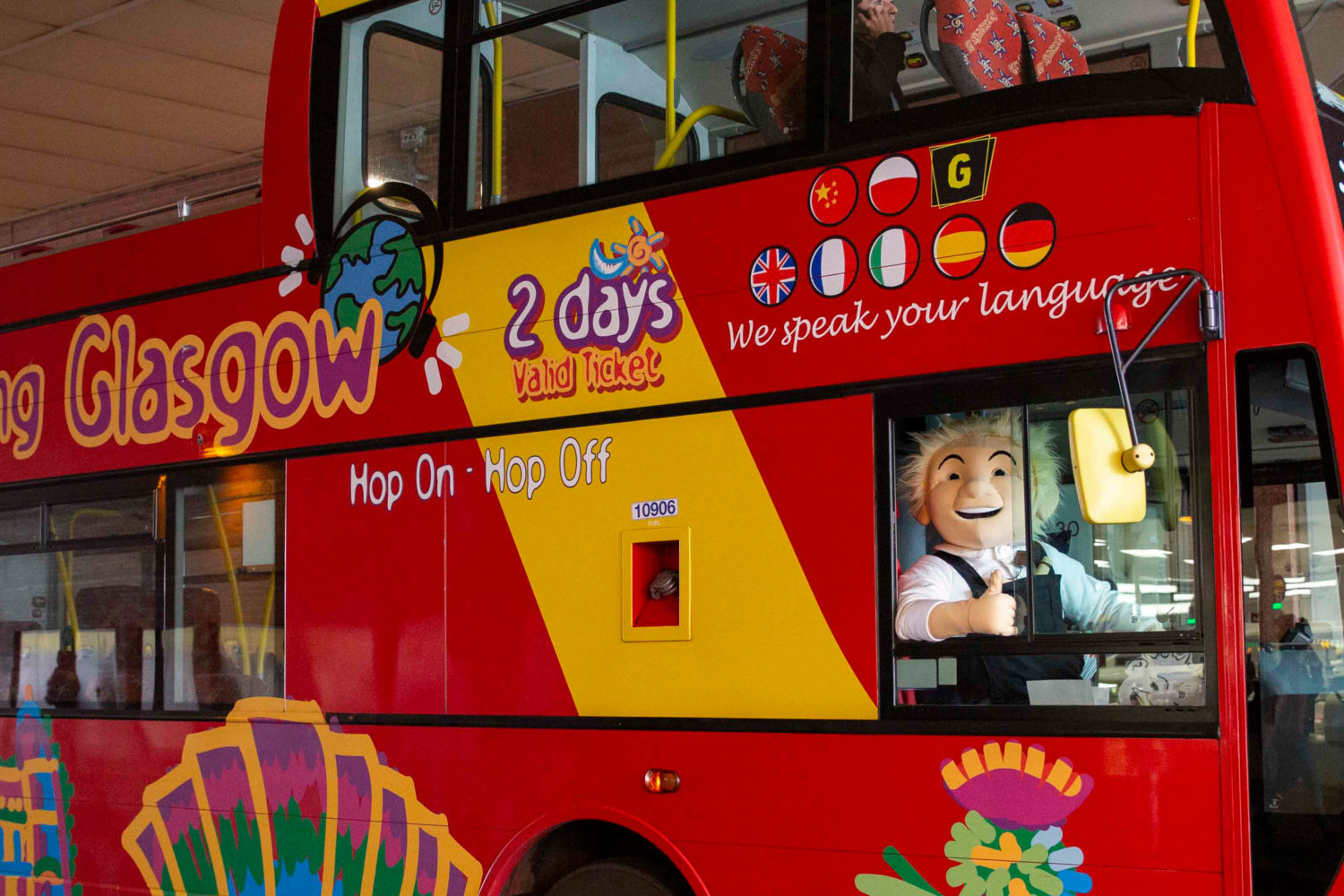 man in oor wullie costume waves out of city sightseeing bus